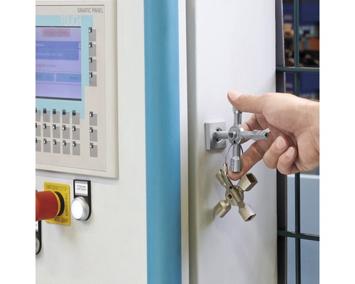 Ein Mann bedient einen Schaltschrank mit einem Universalschlüssel.