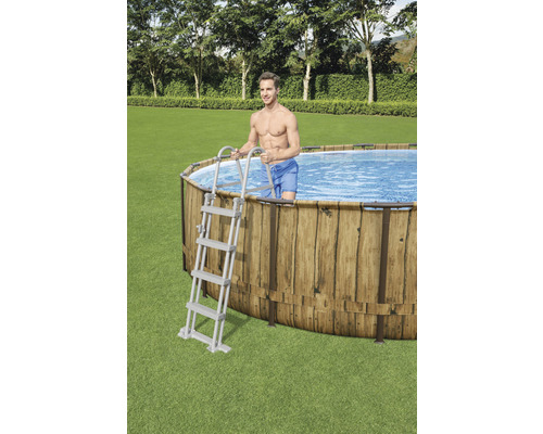 Ovaler Swimmingpool mit Holzverkleidung und Leiter im Garten.