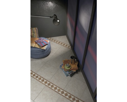 Raumansicht mit Fliesenboden, Sessel und Leselampe.