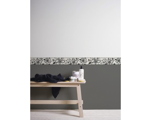 Badezimmergestaltung mit floraler Bordüre, Handtuch und Pflegeprodukten auf einer Holzbank.