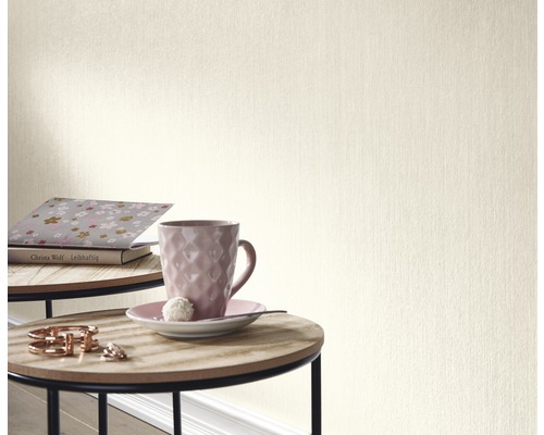 Nahaufnahme einer beigen Tapete in einem Raum mit Tisch und Dekoration.