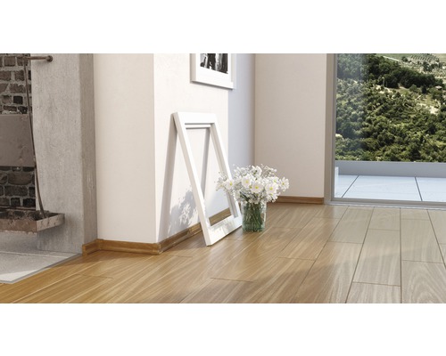 Holzfußboden mit weißem Bilderrahmen und Blumen in einem hellen Raum