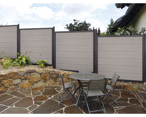 Gartenszene mit Sichtschutzzaun und Sitzgruppe auf Steinterrasse
