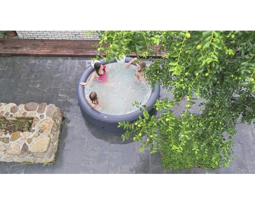 Draufsicht auf einen aufblasbaren Whirlpool mit Personen im Garten