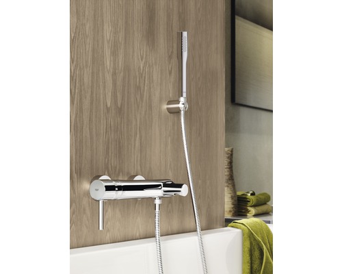 Aufputz-Duscharmatur mit Handbrause vor Holzwand und Badewanne