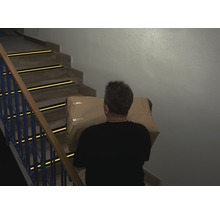 Mann trägt Paket auf Treppe mit Antirutschstreifen
