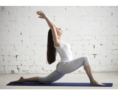 Frau in Yoga-Pose auf einer Yogamatte