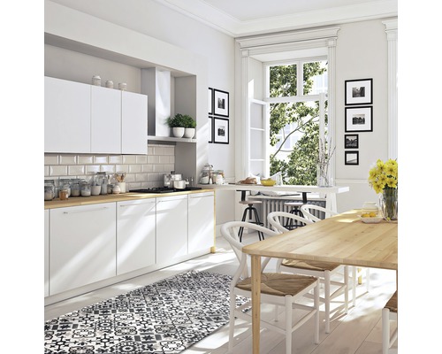 Helle Küche mit weißen Schränken, Holzarbeitsplatten, Esstisch und gemustertem Teppich