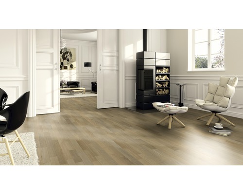 Wohnzimmer mit Holzboden, Kaminofen und Sesseln