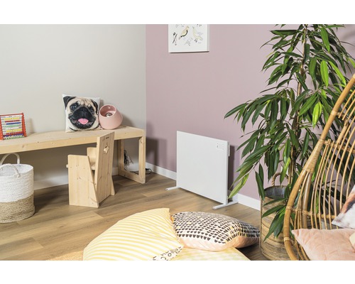 Hell eingerichtetes Kinderzimmer mit Heizkörper, Holztisch und Sitzgelegenheit.