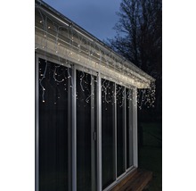 Beleuchtete Eiszapfenlichterkette am Dach eines Hauses