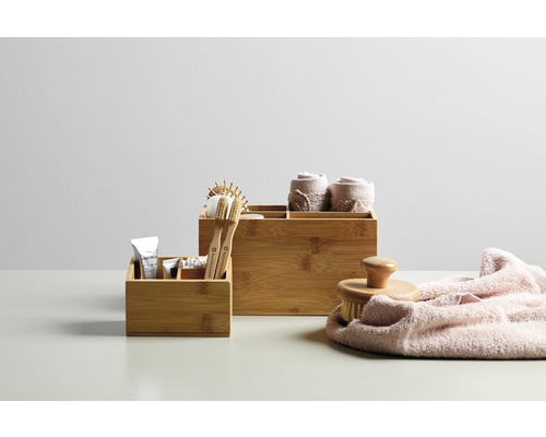 Badezimmer-Szene mit Bambus-Aufbewahrungsboxen, Bürste und Handtüchern