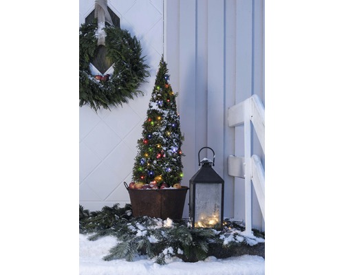 Winterliche Außendekoration mit beleuchtetem Baum, Kranz und Laterne