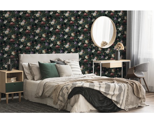 Schlafzimmer mit floral gemusterter Tapete, Bett, Nachttisch, Spiegel und Schreibtisch