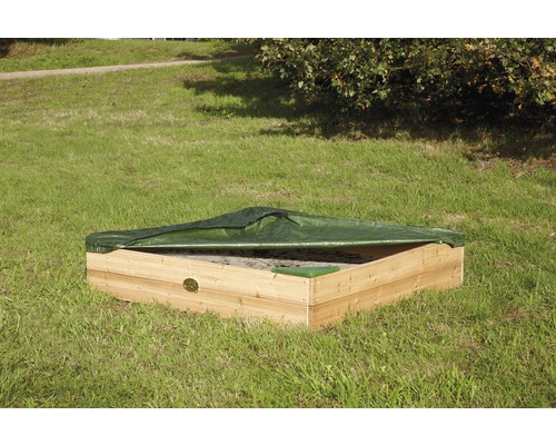 Quadratischer Sandkasten aus Holz mit grüner Abdeckung auf einer Wiese