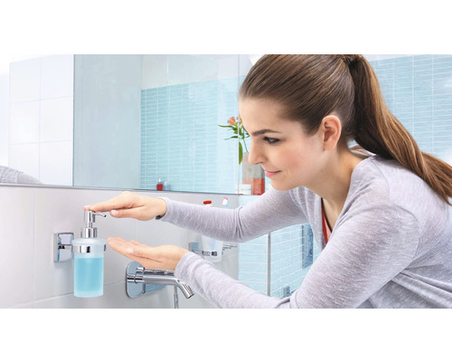 Frau benutzt Seifenspender im Badezimmer