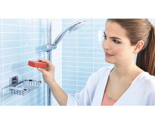 Frau legt Seife in eine Seifenablage unter einer Duschstange