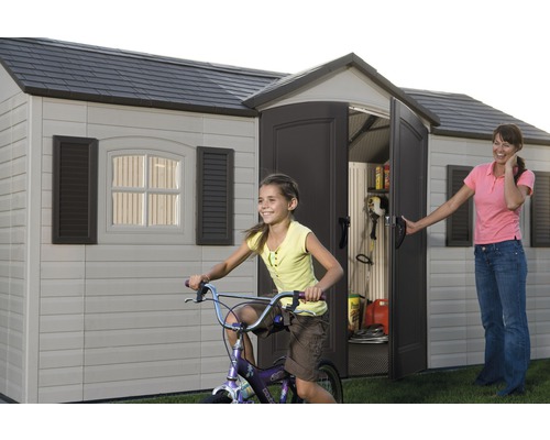 Gartenschuppen mit offenstehender Tür, spielendes Kind auf dem Fahrrad und Frau