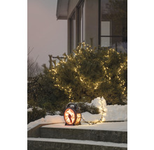 Dekorative Außenansicht mit beleuchteter Laterne und Lichterkette im Wintergarten.