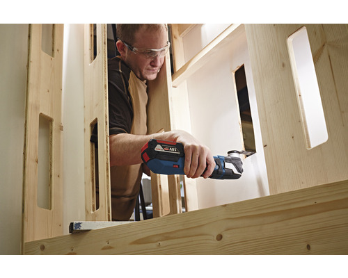 Mann arbeitet mit einem Multifunktionswerkzeug an einem Holzrahmen