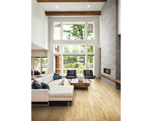 Heller Wohnraum mit Sofa, Sesseln, Kamin und großem Fenster