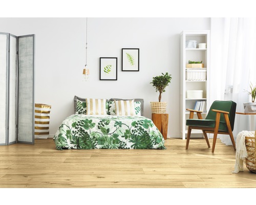 Heller Schlafraum mit Holzboden, Bett, Sessel und Dekoration