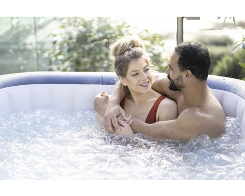 Paar entspannt in einem aufblasbaren Whirlpool im Freien.