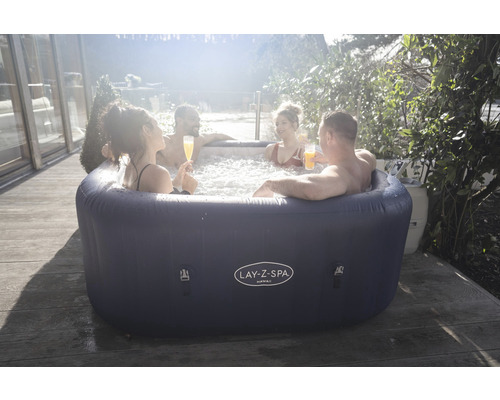 Personen entspannen im aufblasbaren Lay-Z-Spa Hawaii Whirlpool auf einer Holzterrasse