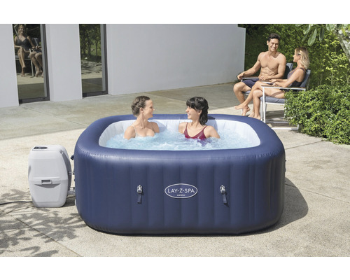 Aufblasbarer Lay-Z-Spa Hawaii Whirlpool mit zwei Frauen im Wasser und zwei Personen im Hintergrund