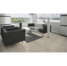 Heller Raum mit Bodenbelag, Sofa, Sesseln und Tisch