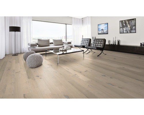 Heller Holzboden in einem modern eingerichteten Wohnzimmer mit Sofa, Sesseln und großem Fenster.