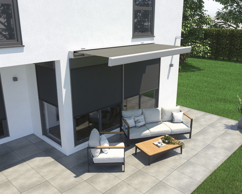 Terrasse mit Markise, Sitzgruppe und Pflastersteinen vor einem Haus