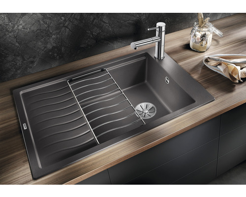 Spüle mit Abtropffläche, Abtropfgitter und Spültischarmatur auf einer Arbeitsplatte