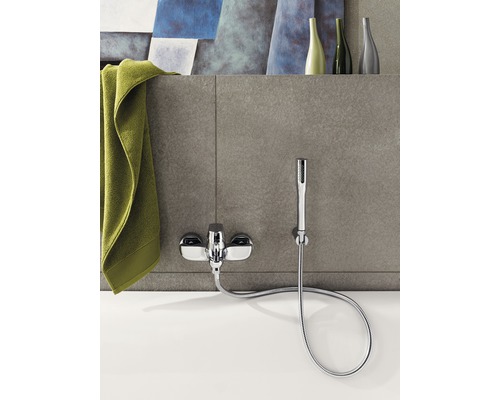 Aufputz-Badearmatur mit Handbrause und Handtuch auf Badewanne