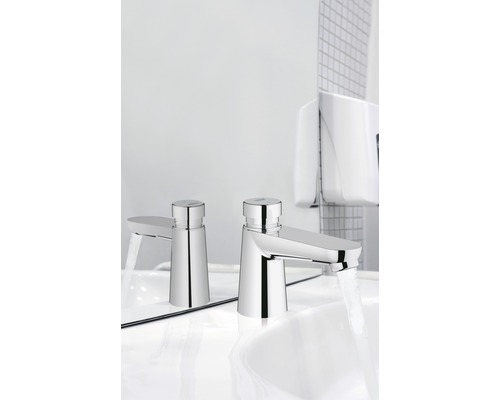 Zwei Waschtischarmaturen mit Wasserstrahl auf einem weißen Waschbecken