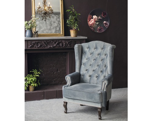 Interieuransicht mit Ohrensessel, Kamin und Dekoration