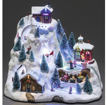 Dekorative animierte Winterlandschaft mit Häusern, Bäumen, Figuren und einer Eisenbahn