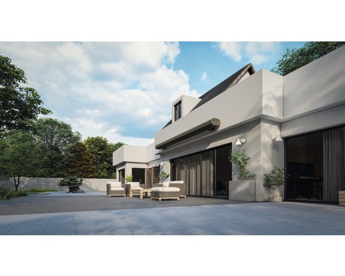 Außenansicht eines modernen Hauses mit Markise, Gartenmöbeln und gepflegtem Garten