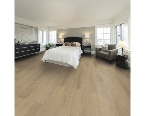 Schlafzimmer mit Holzboden, Bett, Kommode und Sitzgelegenheit