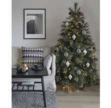 Dekoratives Wohnzimmer mit Weihnachtsbaum, Sofa, Tisch und gerahmtem Bild