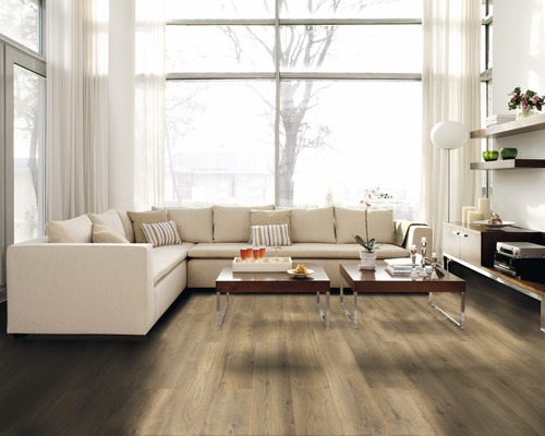 Heller Wohnraum mit Laminatboden, Ecksofa und großen Fenstern