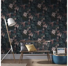 Wohnzimmer mit floral gemusterter Tapete, Bank, Stehlampe und Beistelltisch.