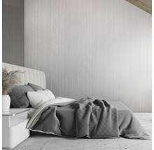 Schlafzimmer mit Bett, Nachttisch und dekorativer Wandverkleidung für eine ruhige Atmosphäre.