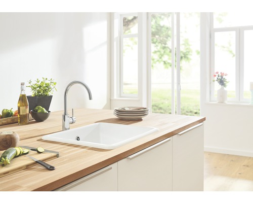 Helle Küche mit Spüle, Armatur und Holzarbeitsplatte.