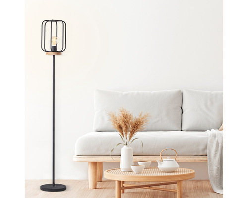 Stehleuchte 1-flammig HxØ 163x25 cm Tosh schwarz/antik/braun mit Fußschalter Stehlampe mit Lampenschirm aus Metall und Holz in einem hellen Wohnzimmer.