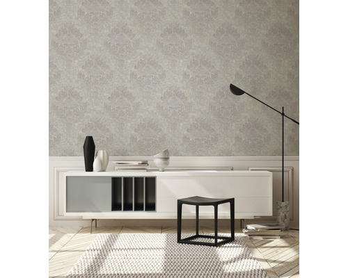 Dekoratives Wohnzimmer mit gemusterter Tapete, Sideboard, Hocker und Stehleuchte.