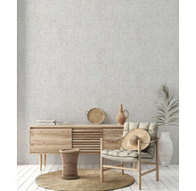 Wohnzimmer mit Holzkommode, Sessel, Dekoration und rundem Teppich