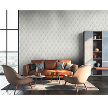 Wohnzimmer mit gemusterter Tapete, Ledersofa und Sesseln
