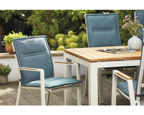 Gartenszene mit Gartentisch und Gartenstühlen mit Polsterauflagen