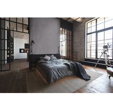 Schlafzimmer im Loftstil mit Bett, Teppich und großen Fenstern
